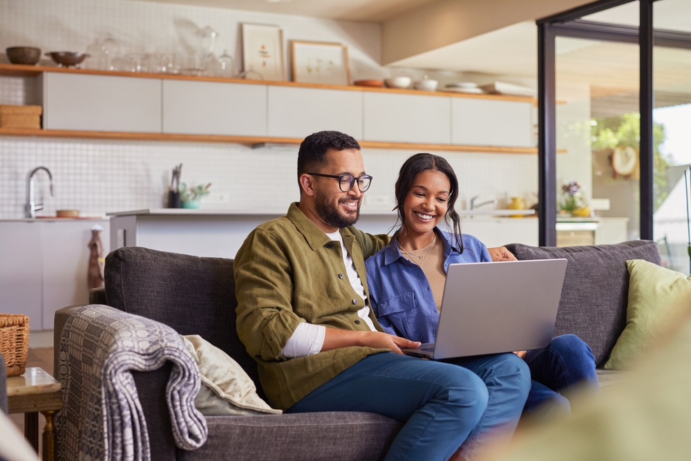 Young,Mixed,Race,Couple,Watching,Movie,On,Laptop,While,Relaxing