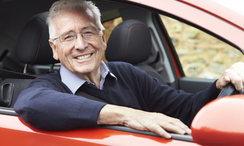 Old man smiling car driving